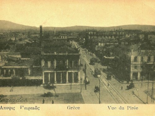 Στην καρδιά του αρχικού Χιακού συνοικισμού «Άποψις Πειραιώς». Φωτογραφία υπογεγραμμένη από τον Αναστάσιο Γαζιάδη. Πρόκειται για το σημείο της τότε οδού Μιαούλη, σήμερα Εθνικής Αντιστάσεως. Αριστερά η πλατεία Θεμιστοκλέους, δεξιά η πλατεία Αγίας Τριάδος. Ο δρόμος που ανοίγεται μπροστά από τις πλατείες είναι η οδός Ομήρου, τώρα Μακράς Στοάς. 